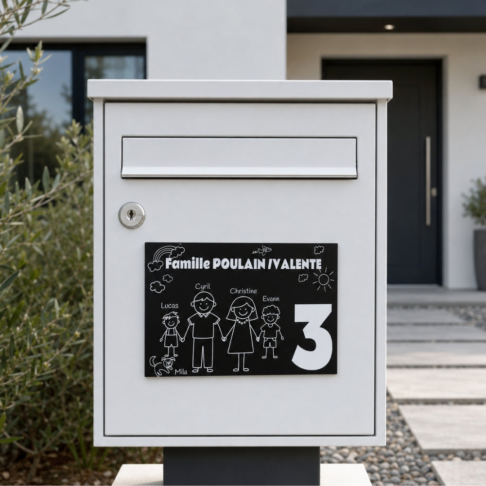 Plaque famille gravée noire avec personnages et chien sur une boîte aux lettres blanche